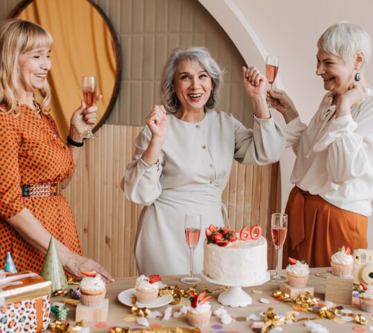 showing normal-minimum-pension-age. Three retired women celebrating their 60th birthday