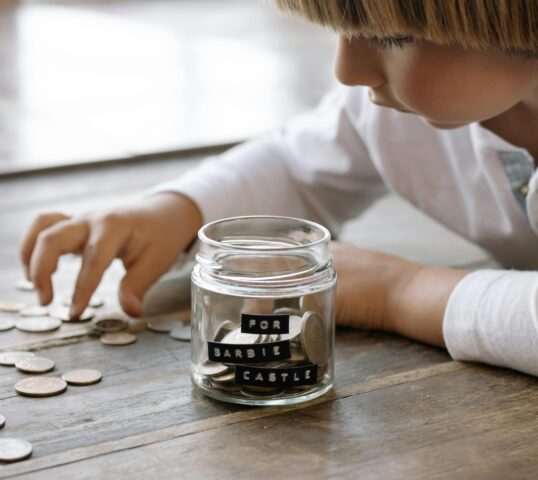 Little Child Playing with Coins on Floor
